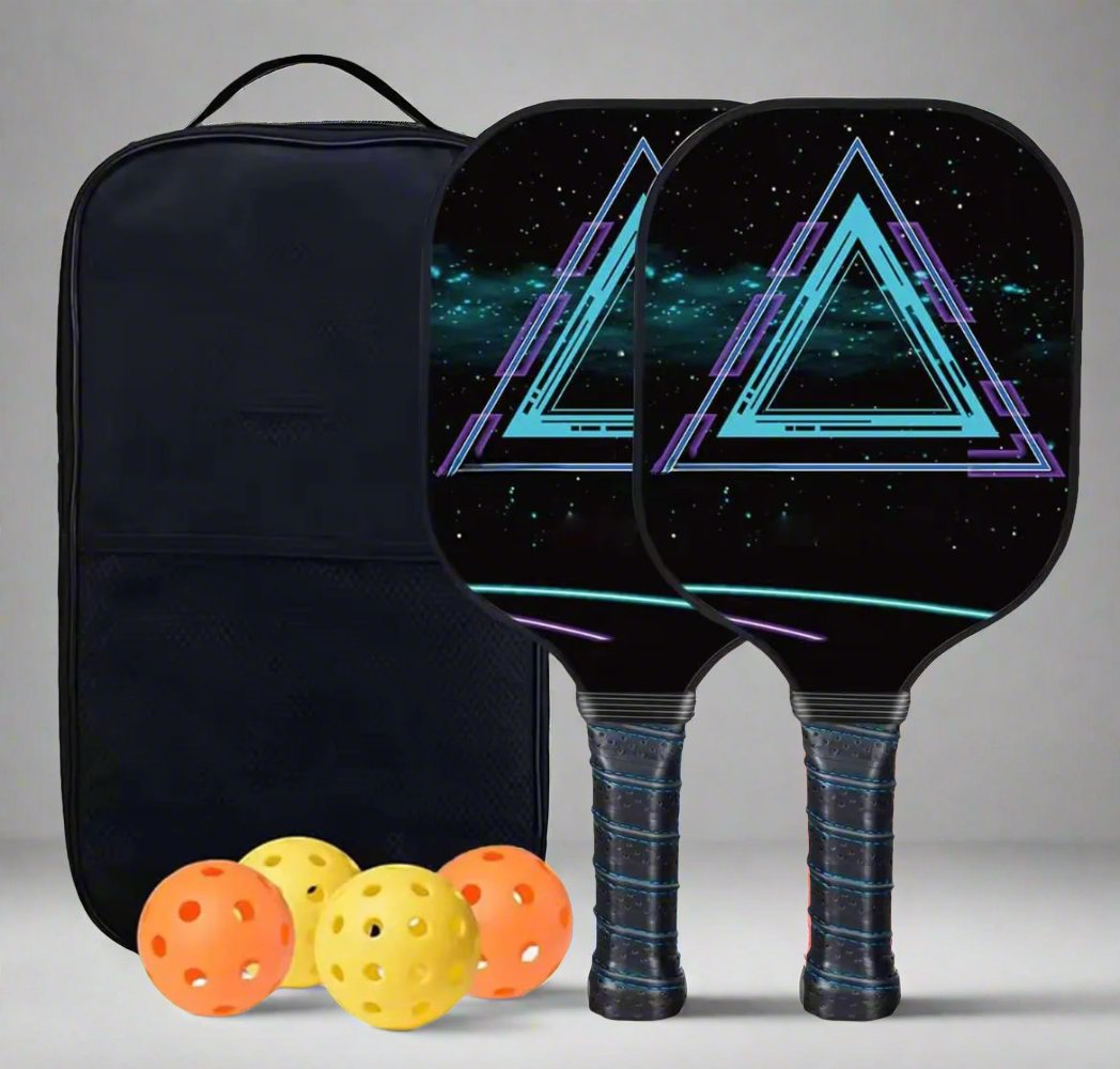Two carbon pickleball paddles with a geometric design, accompanied by a black carrying bag and four yellow pickleball balls.