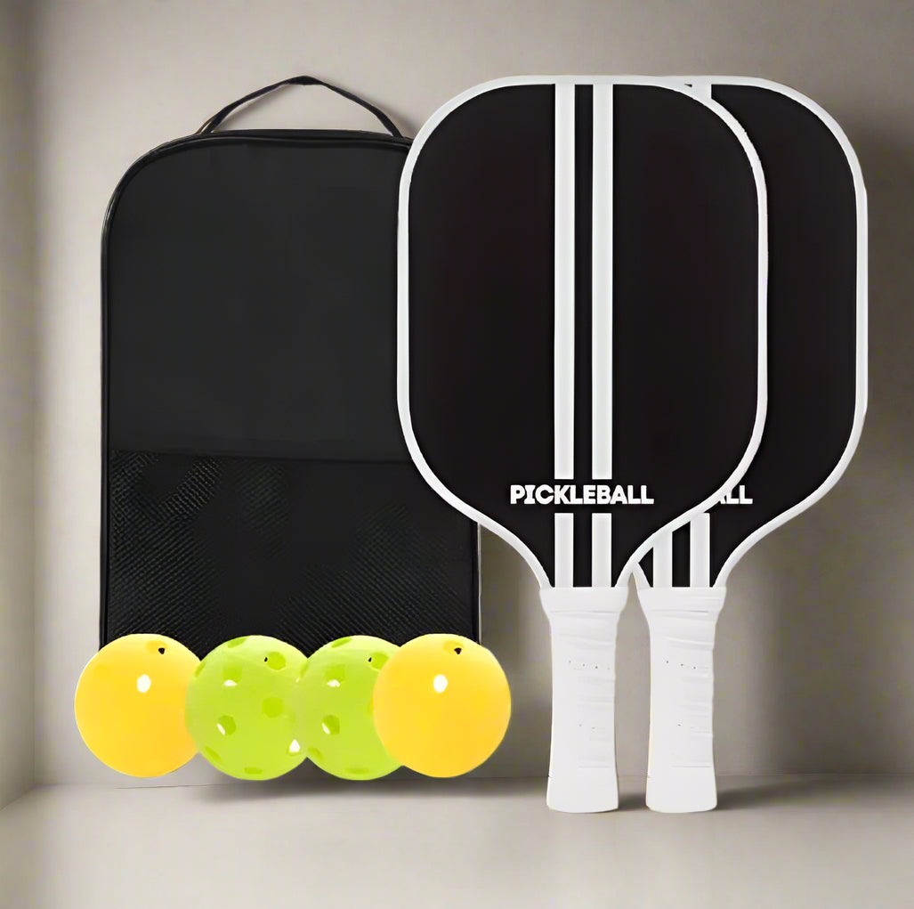 Two pickleball paddles with a black bag and yellow balls on a white background