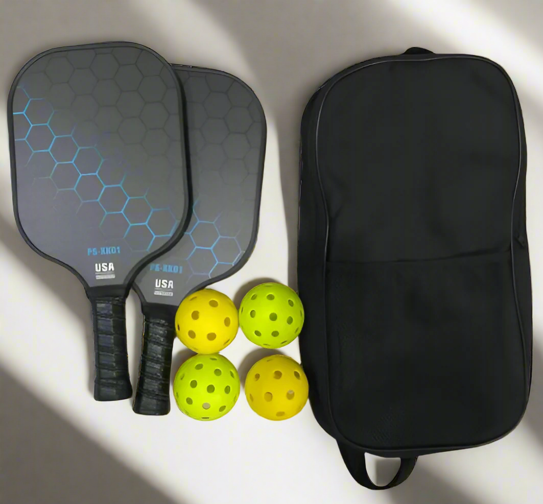 Two pickleball paddles, four yellow pickleballs, and a black bag on a white background