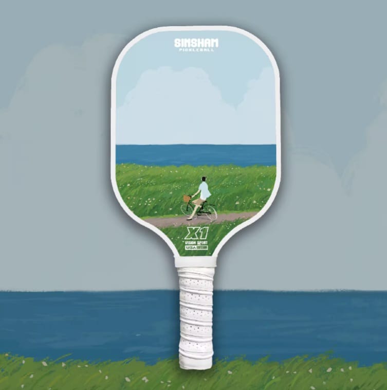 Single Pickleball Paddle with an idyllic design, a person on a bicycle on a dirt road looking at the scenery in front of him which is the grass and the sea in an artistic form.