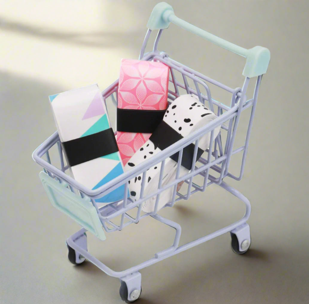 Set of 3 Pickleball grip tapes in a plastic wrapper. One of the grip tape is a pink flower design, another is black and white, like a cow design. The last is different color shapes mixed with a white background.