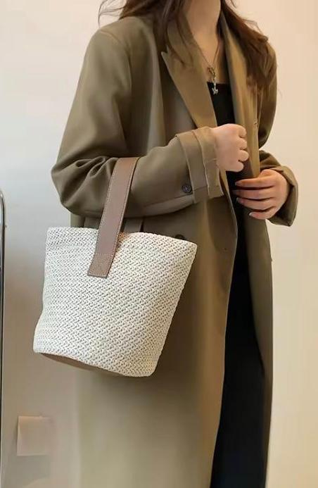 Women in black dress carrying a straw bucket bag