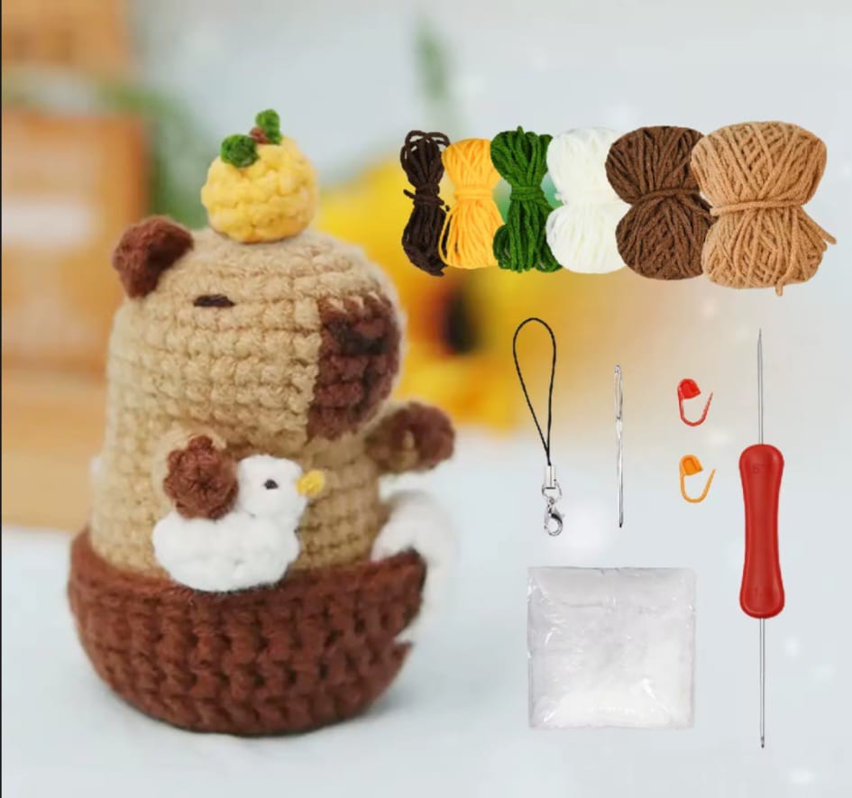 Jojo the capybara crochet kit with and orange on top of his head and a duckling by his side 