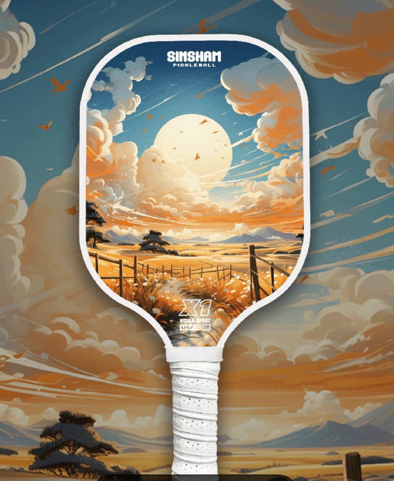Single Pickleball Paddle with a design of a dawn -like sky, a full sun with orange clouds covering one-third of it, a orange coloured field at the bottom with some green trees and fence, in an artistic form. 
