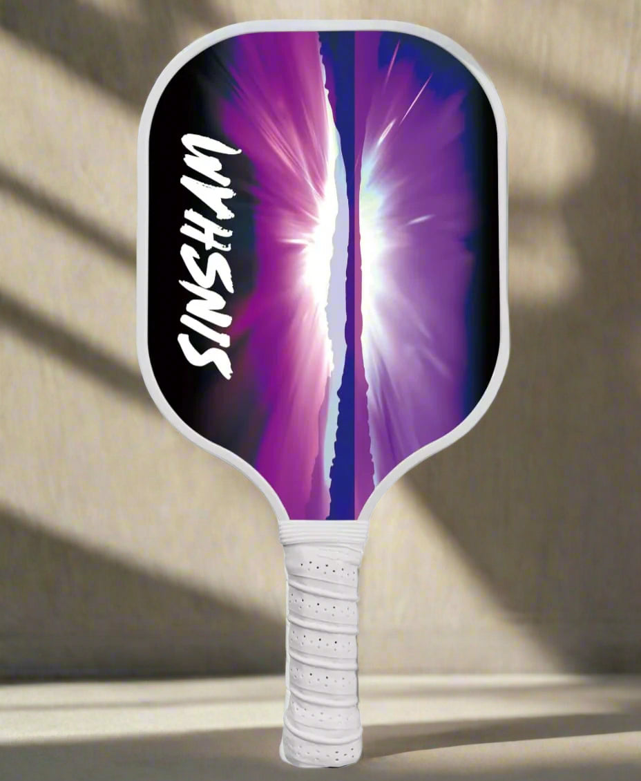 Single Pickleball Paddle with a design of a purple midnight artistic scenery of the sky, mountains and sea. 