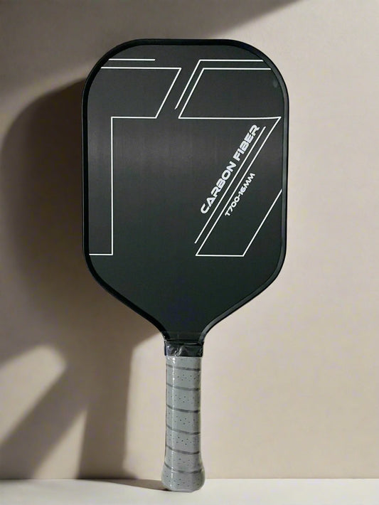 Single professional raw carbon t700 Pickleball paddle with coarse surface for spins. Design is simple, black surface, the words carbon fiber, t700-16mm on it in white and a grey handle.